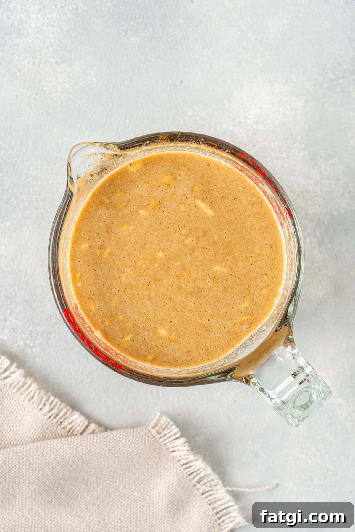 The satay sauce mixed together in a glass jug.