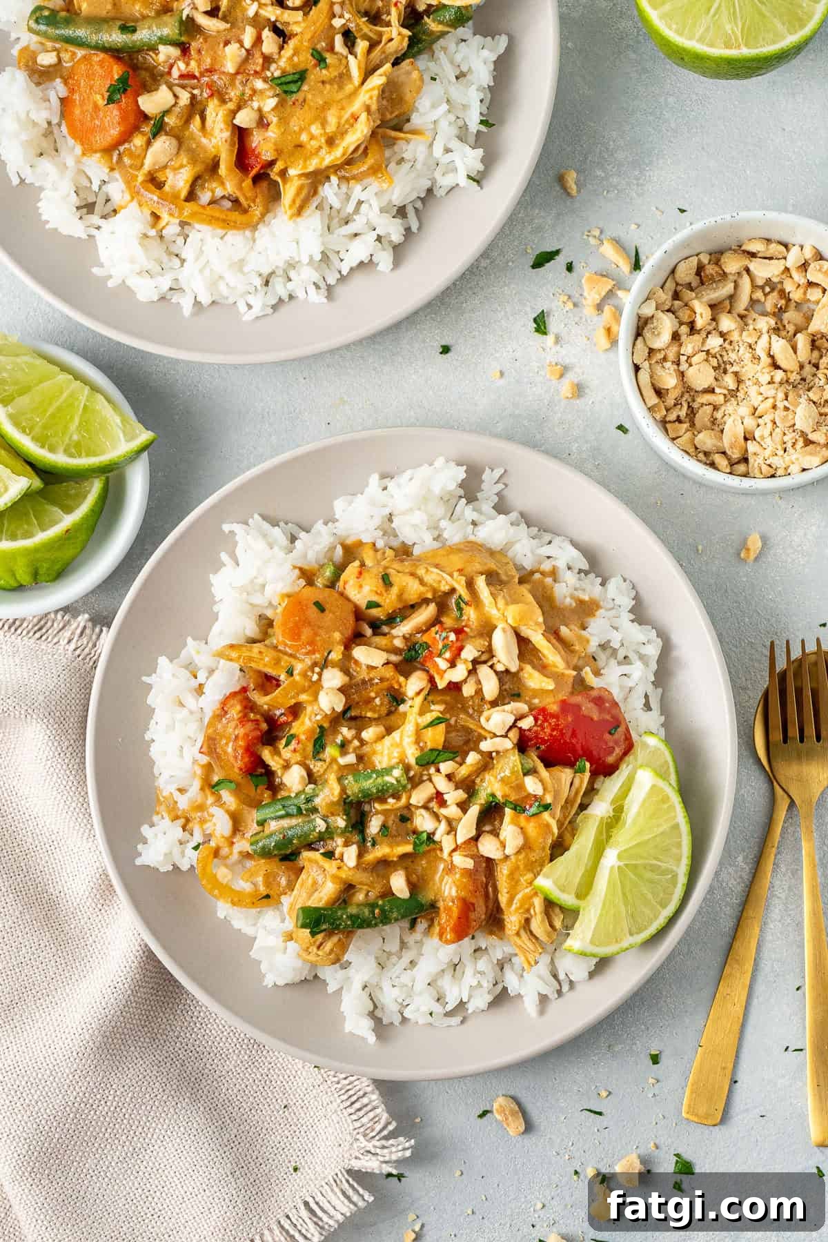 The served satay chicken over rice with fresh lime.