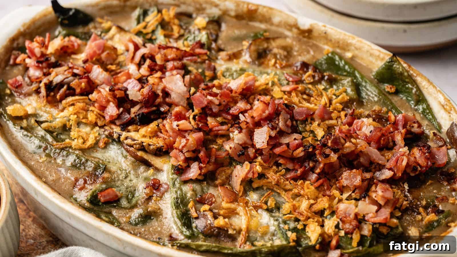 21 Pork Dinner Recipes for When You Need More on the Table 20 A baked casserole topped with chopped bacon, crispy onions, and melted cheese, featuring visible green peppers and a creamy sauce.