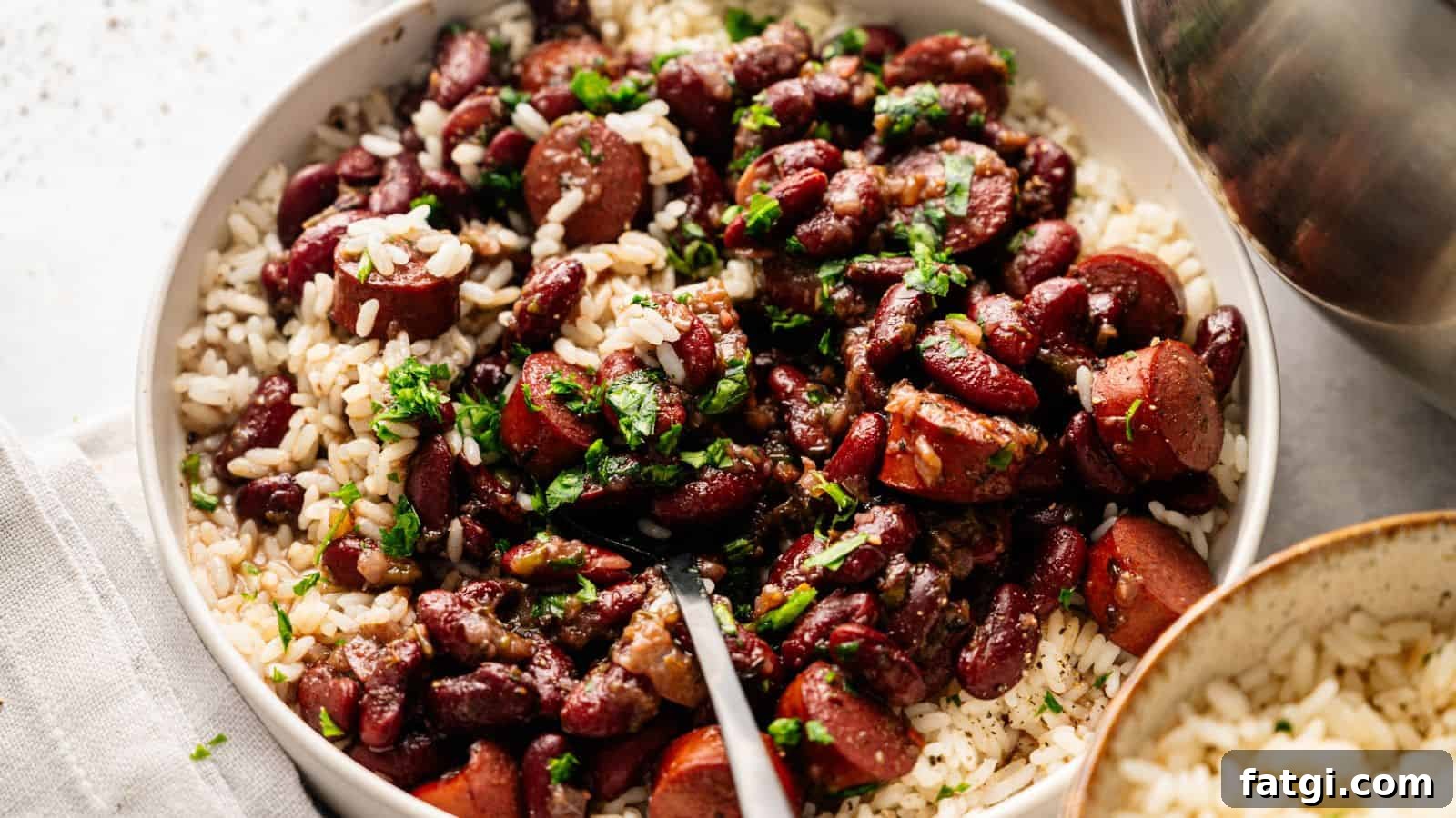 21 Pork Dinner Recipes for When You Need More on the Table 23 A bowl of white rice topped with kidney beans, sliced sausage, and chopped herbs, with a fork resting inside.