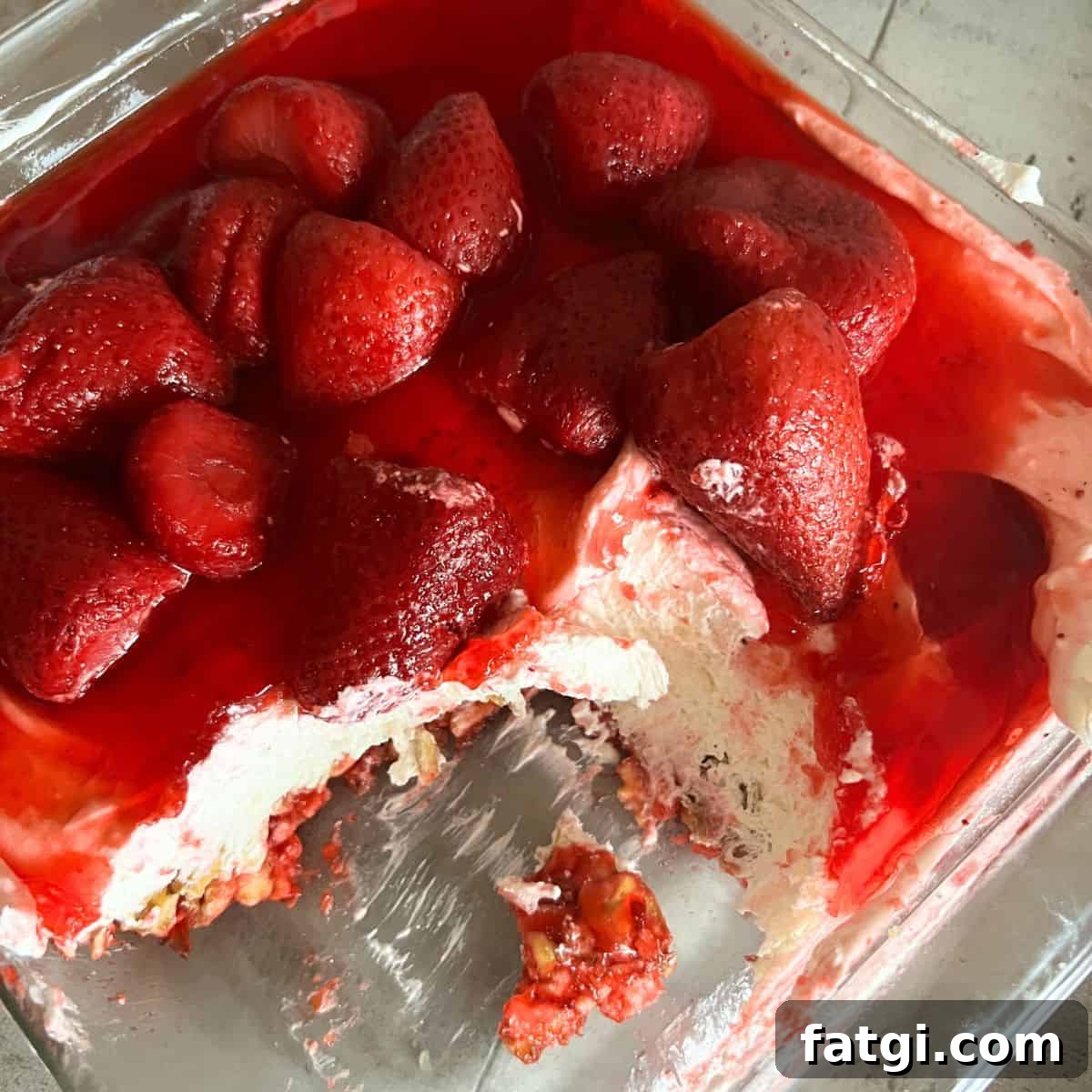 Strawberry pretzel salad with a pretzel crust, cream cheese layer, and strawberry gelatin topping.