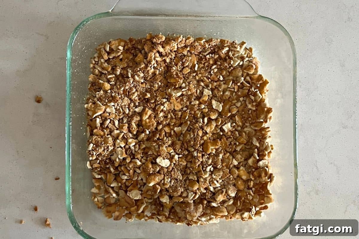 Crushed pretzel crust pressed into a clear baking dish.