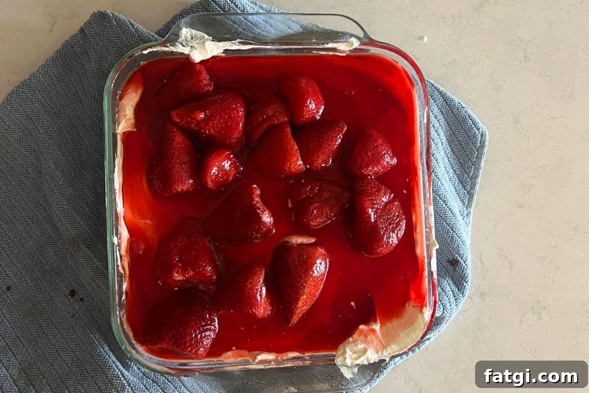 Strawberry gelatin mixture poured over the cream cheese layer.