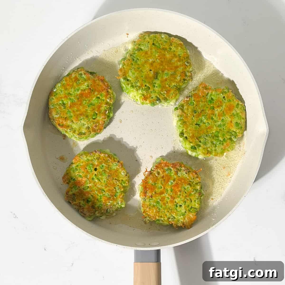 Cheesy Green Pea Fritters Recipe 12 Frying the green pea fritters in a large frying pan.