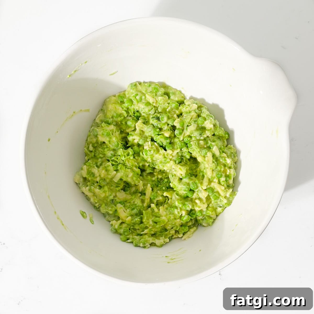 Cheesy Green Pea Fritters Recipe 9 Green pea fritter mixture in a large white bowl.
