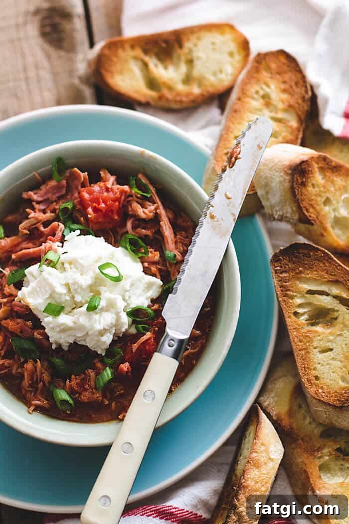 A bowl with the pulled pork gravy on a plate, with ricotta and toasted bread.