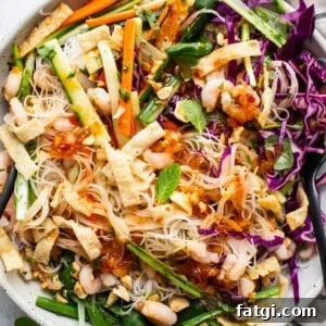 A bowl of asian noodle salad with shrimp and vegetables.