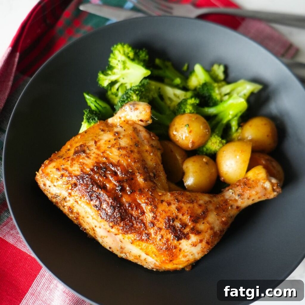 Baked chicken leg quarters with crispy skin, roasted baby potatoes and broccoli on a plate.
