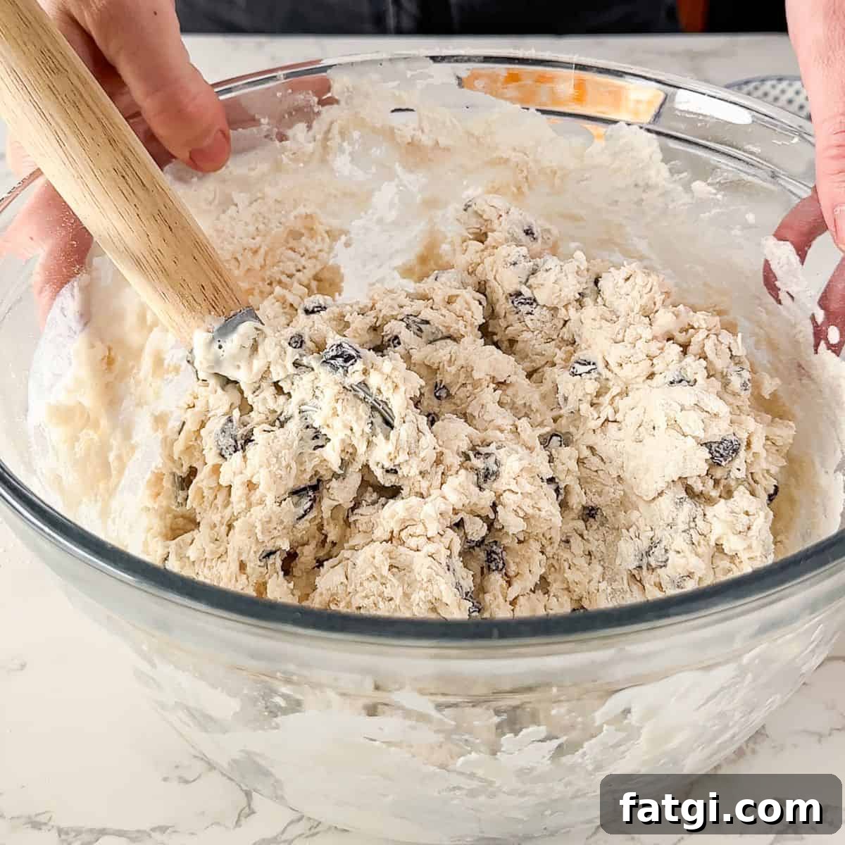 Mixing the raisins and buttermilk into the flour mixture. 
