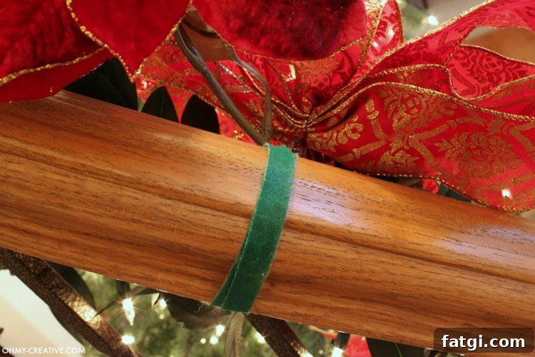 How to Hang Garland on a Staircase Banister 6 Silk poinsettias and bows used to hide Velcro ties on Christmas staircase garland