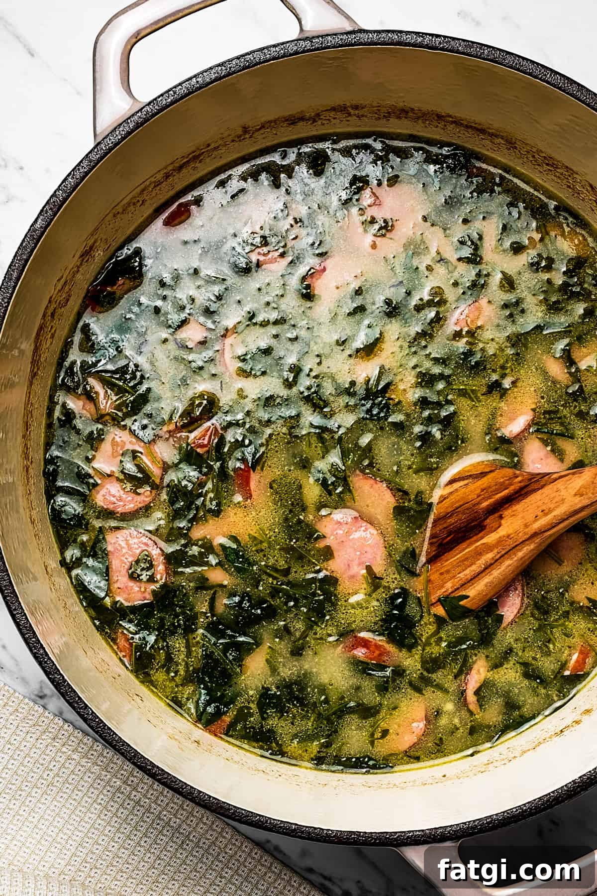 A pot of sausage, kale, and potato soup.