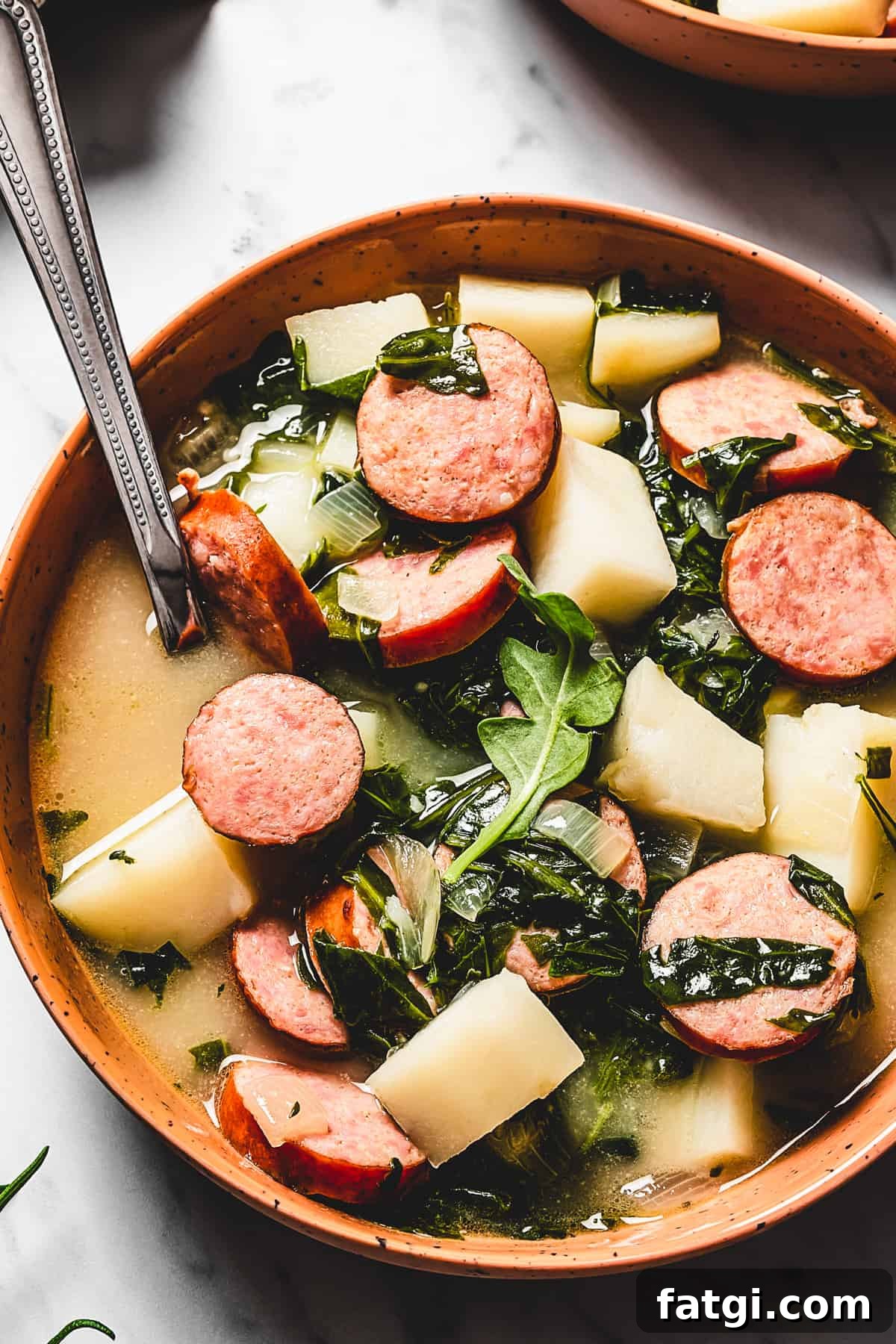A bowl of hearty potato soup with sprigs of fresh rosemary.
