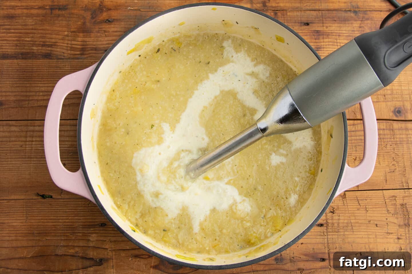 Creamy Cauliflower, Potato and Leek Soup Recipe 7 This is a picture of a big pot with the soup being blended with an immersion blender.