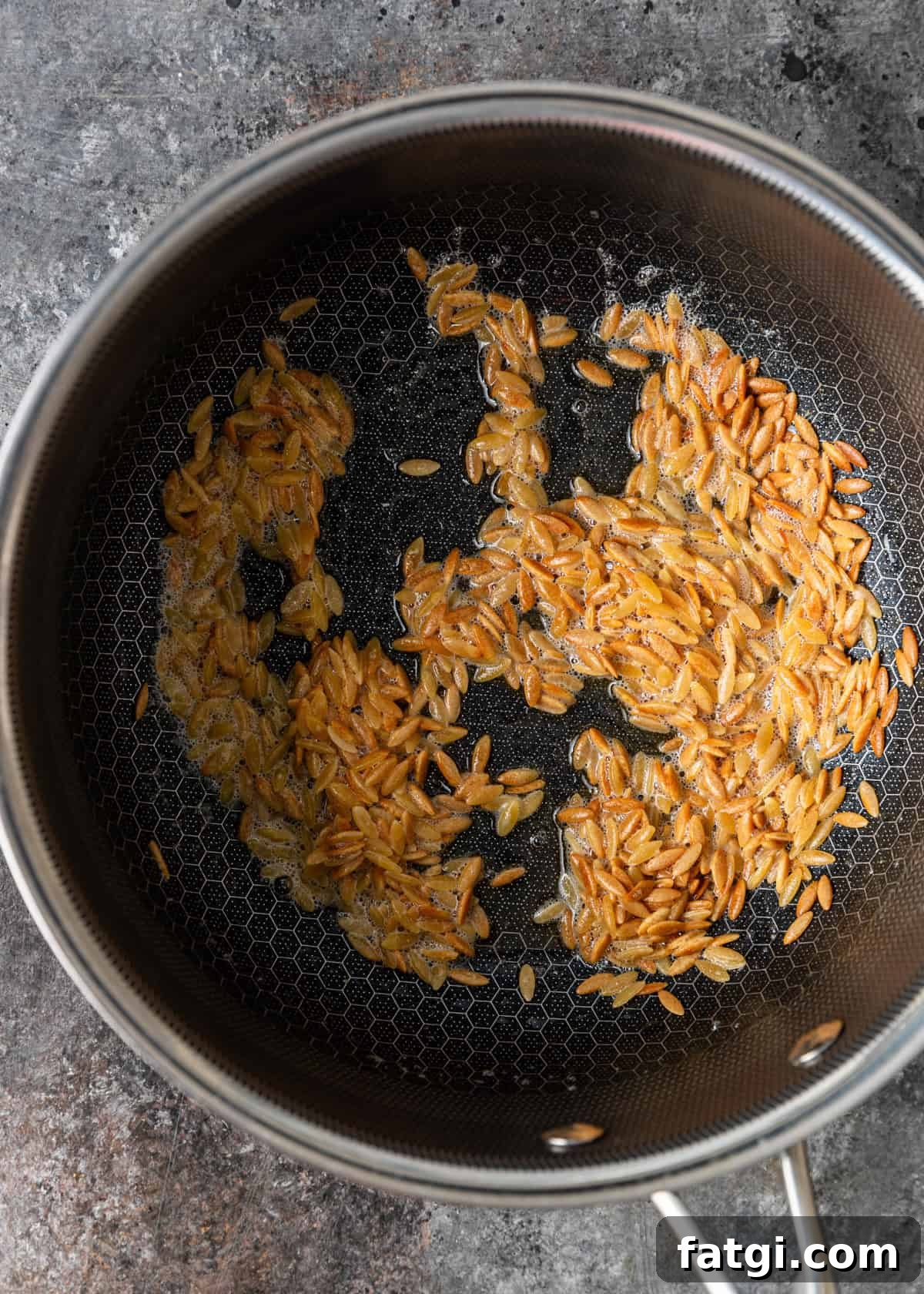 overhead process shot: browning the orzo in butter in a pan