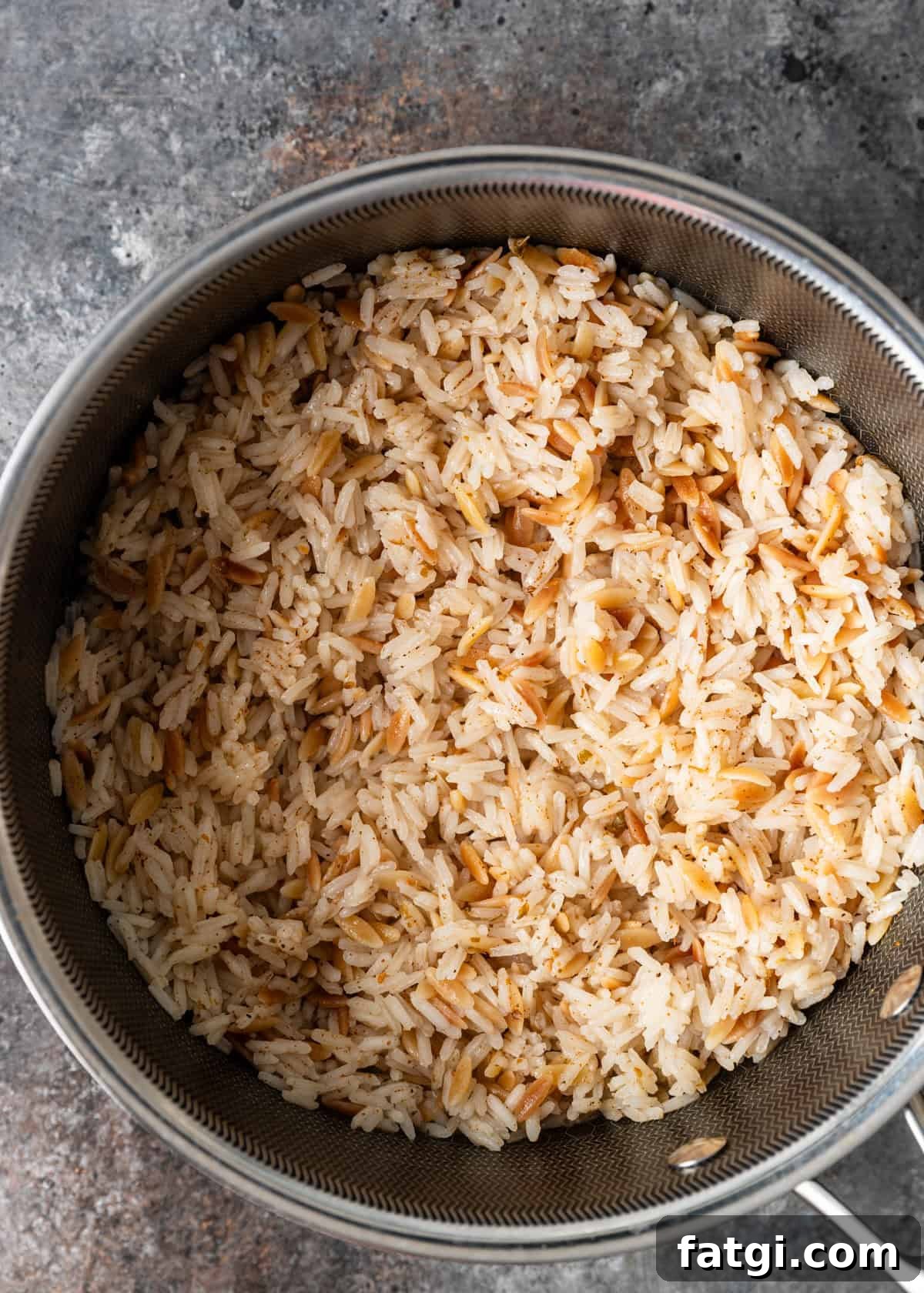 overhead process shot: steaming rice with seasoning and water in a large pan