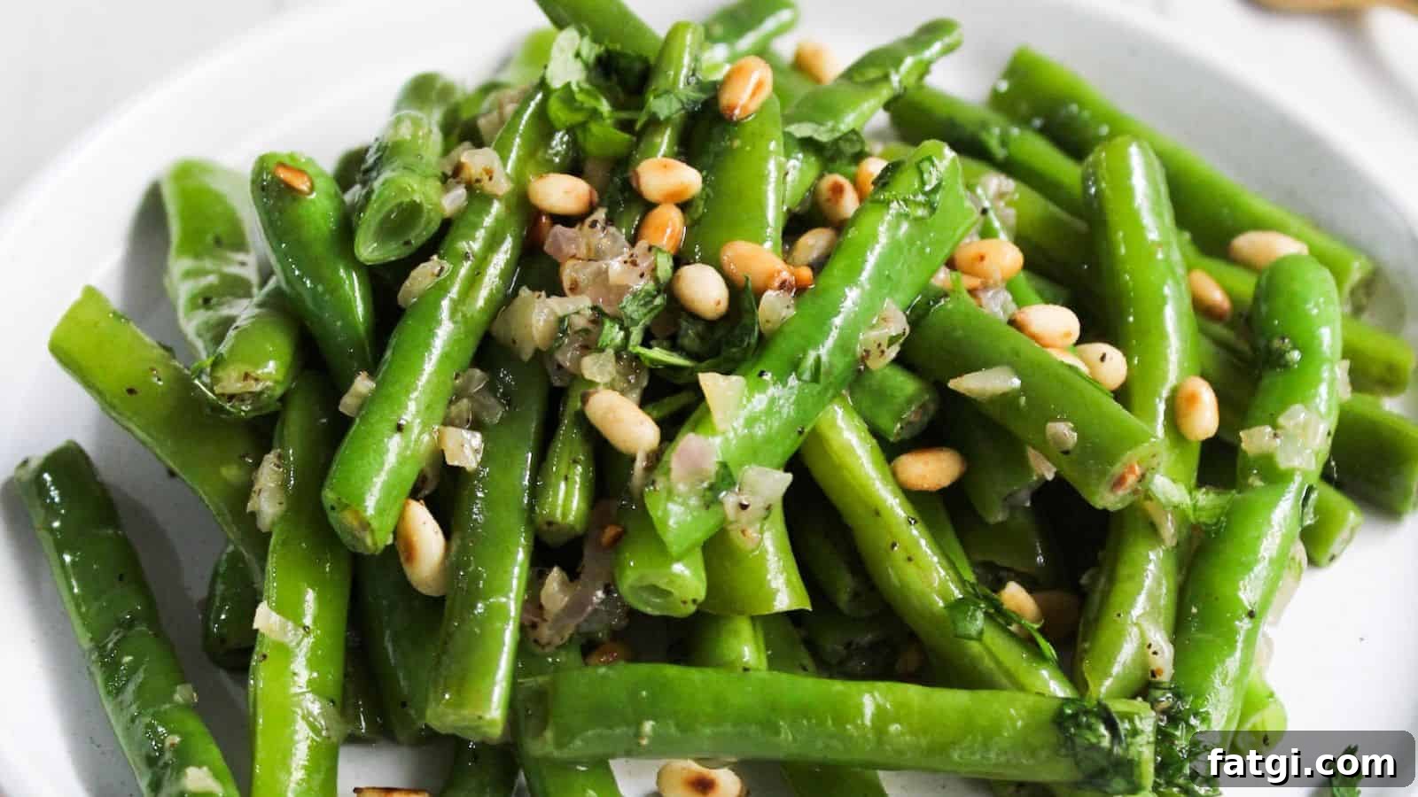 Green beans with pine nuts on a plate.