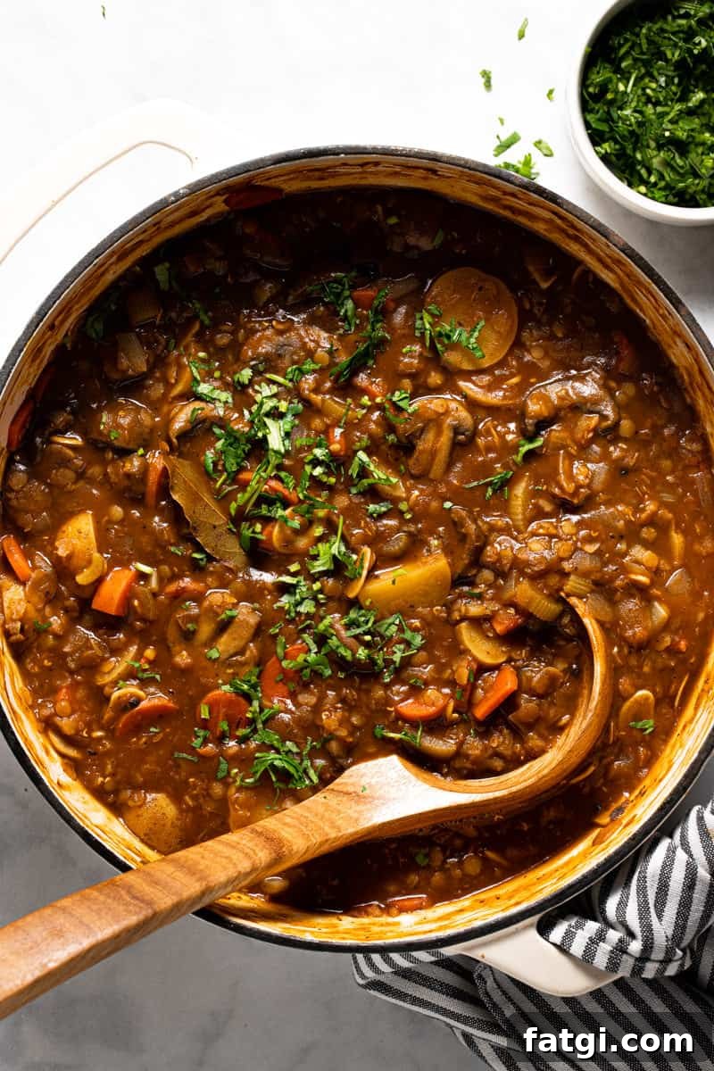 Large white pot filled with vegetable stew garnished with fresh parsley 