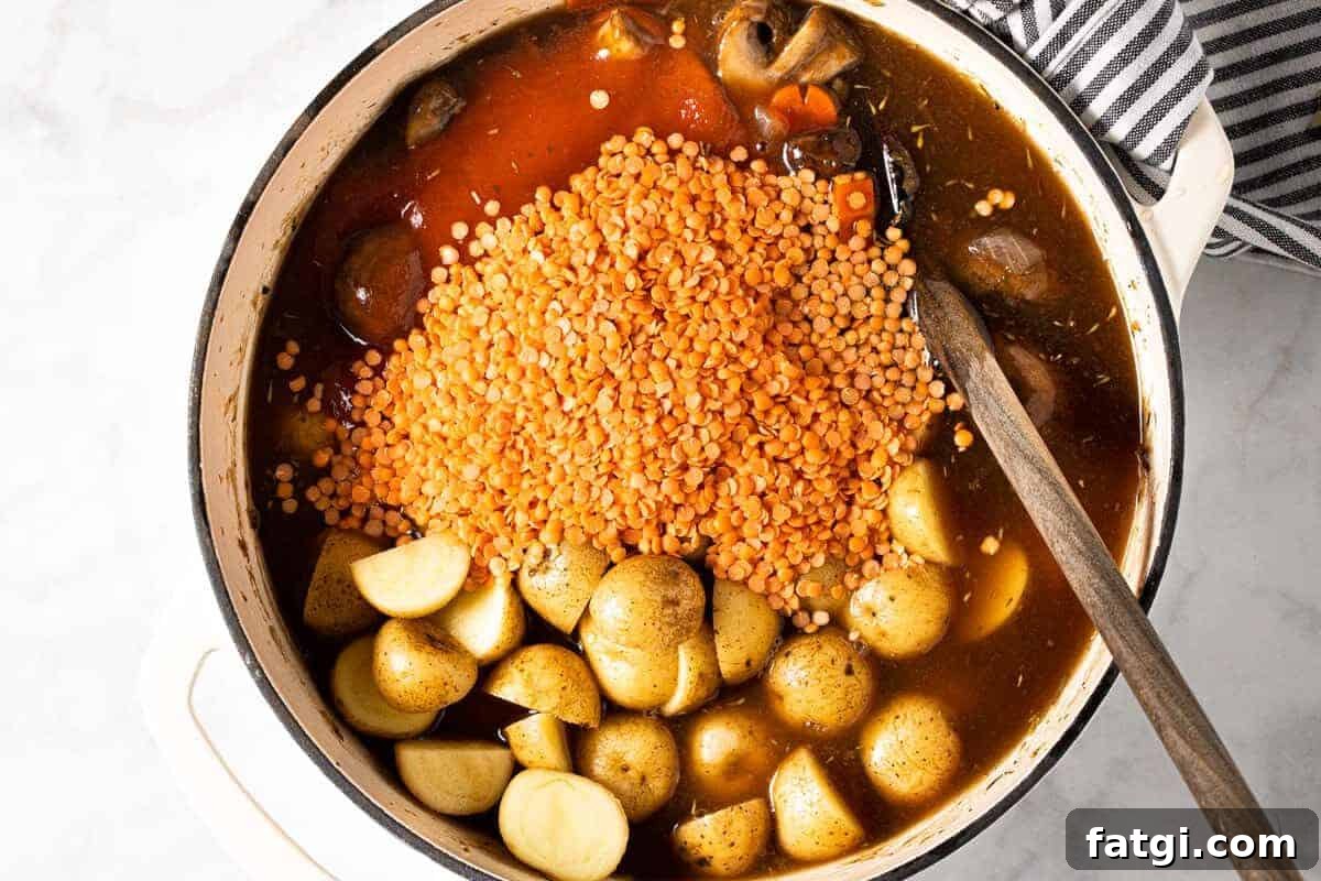 Large white pot filled with ingredients to make this vegetable stew recipe