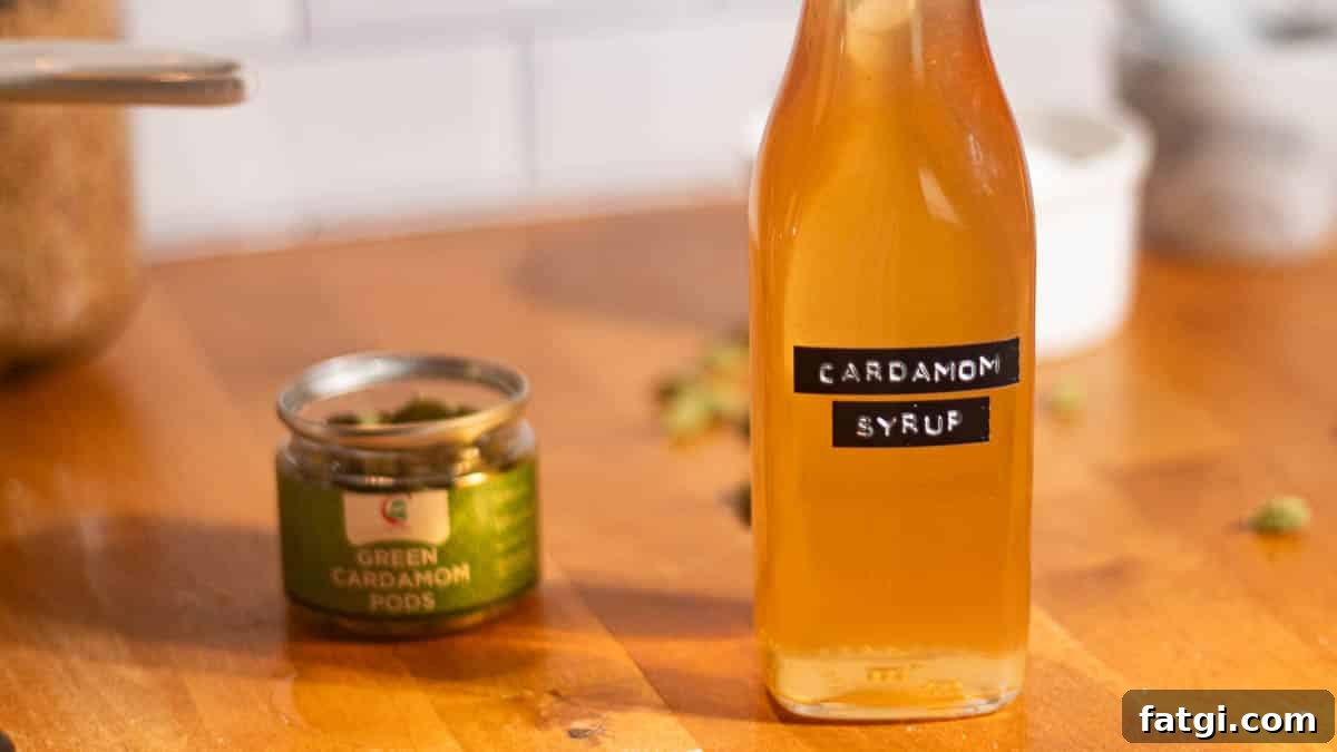 Homemade Cardamom Syrup Recipe for Coffee and Cocktails 3 Bottle of cardamom syrup beside green cardamom pods in a jar, perfect for homemade coffee or cocktail recipes.