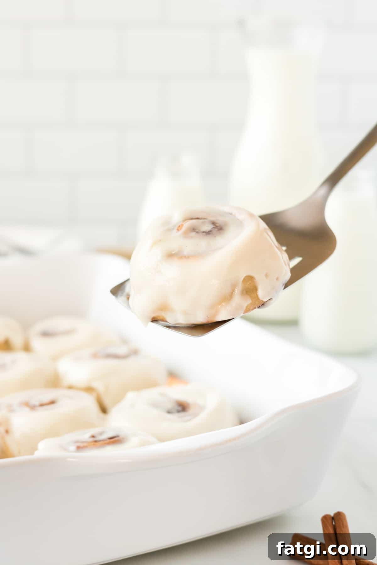 spatula taking a no rise cinnamon roll from the dish