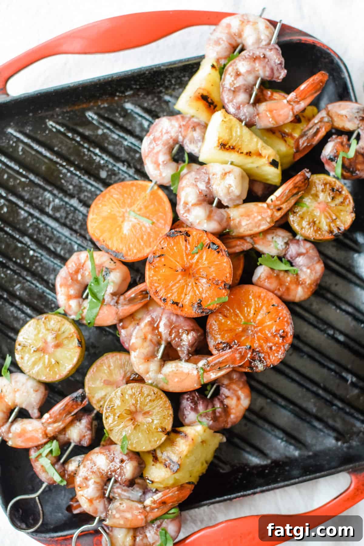 Grilled Shrimp Skewers with Sangria Marinade 2 An overhead image of grilled shrimp skewers sitting on a grill pan with red edges.