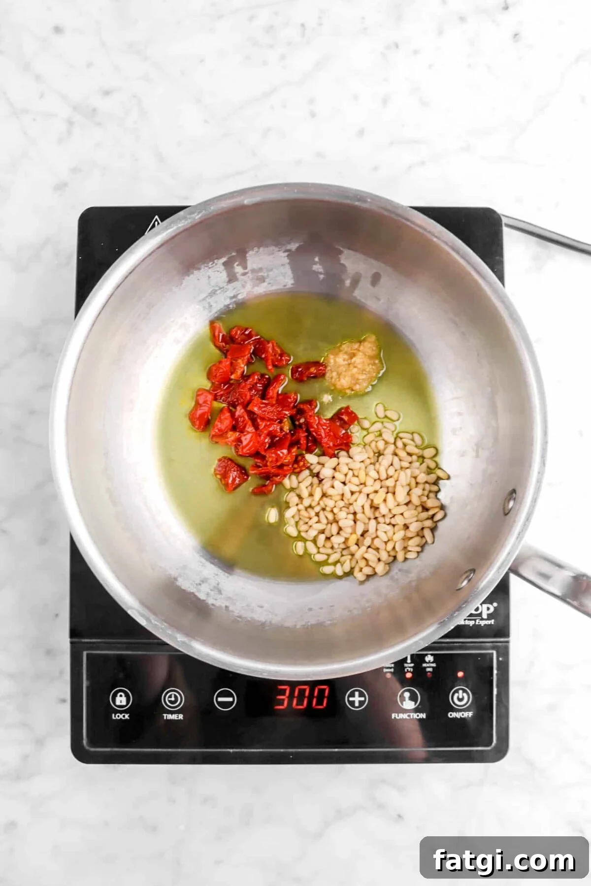 olive oil, pine nuts, sun dried tomatoes, and garlic in sauté pan