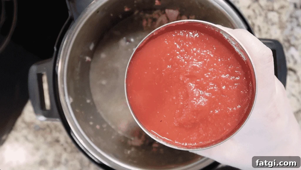 Adding crushed tomatoes to pot