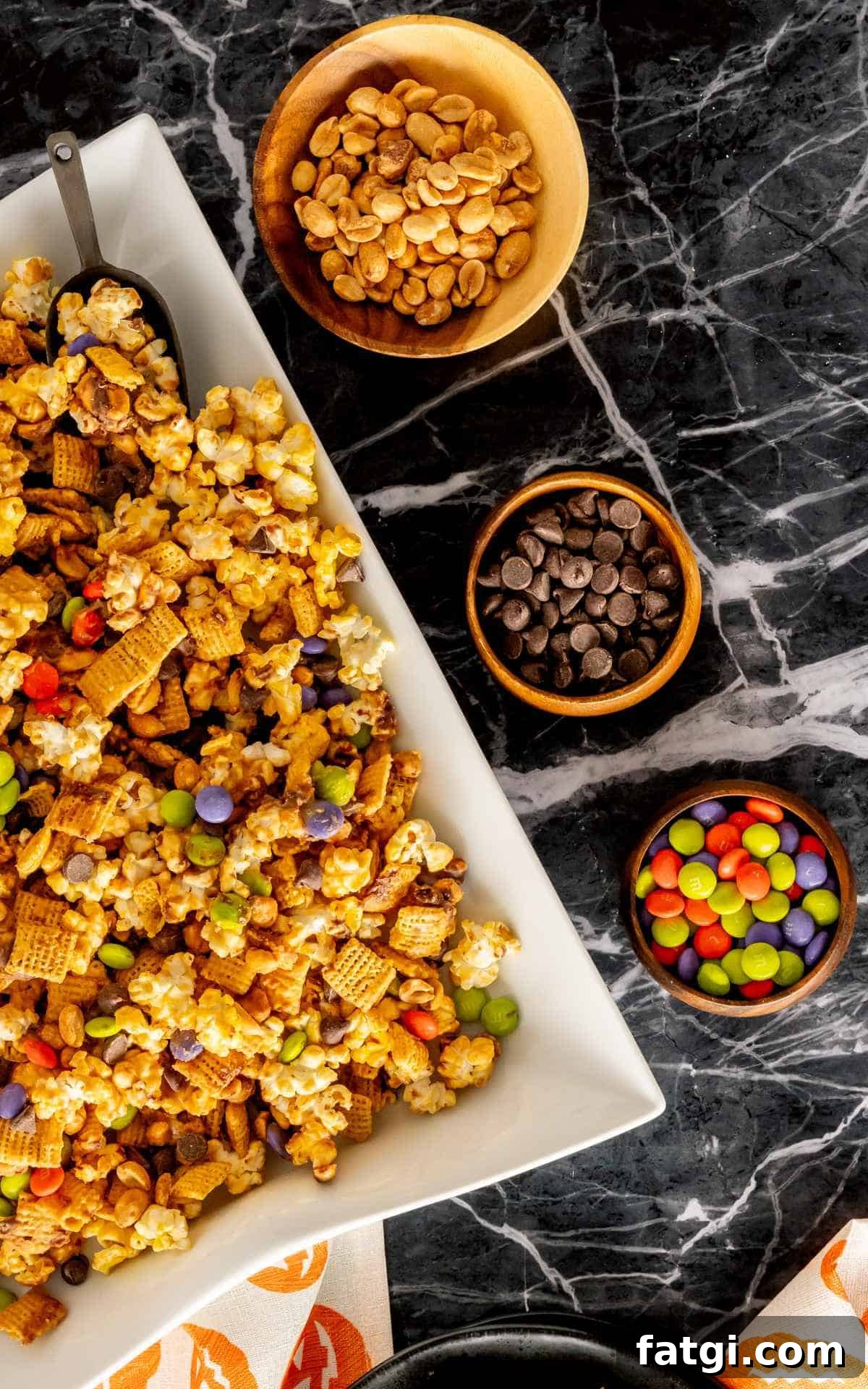 Halloween Monster Munch recipe on a large serving platter with bowls of candy and nuts.