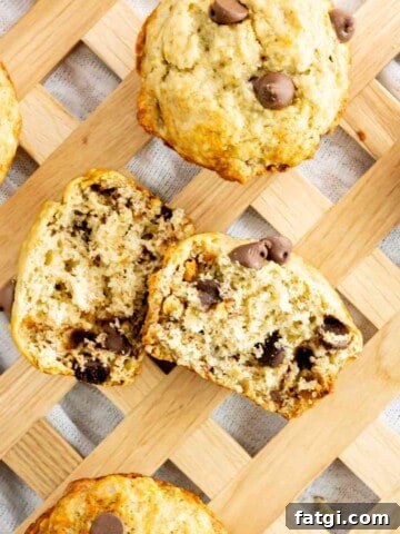 Chocolate Chip Banana Muffins scattered on a serving tray with one cut in half.