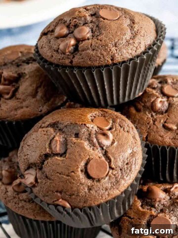 Bakery Style Chocolate Muffins stacked on wire rack.