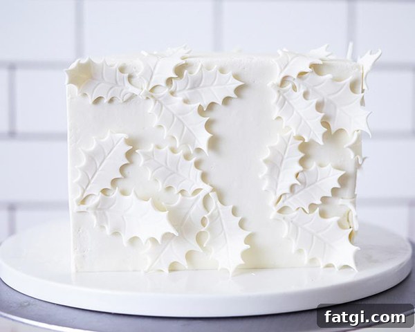 Square cake covered with white fondant holly leaves
