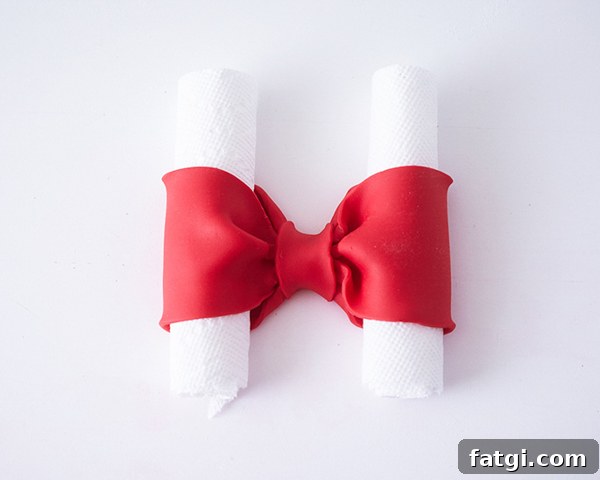Finished red fondant bow drying on parchment