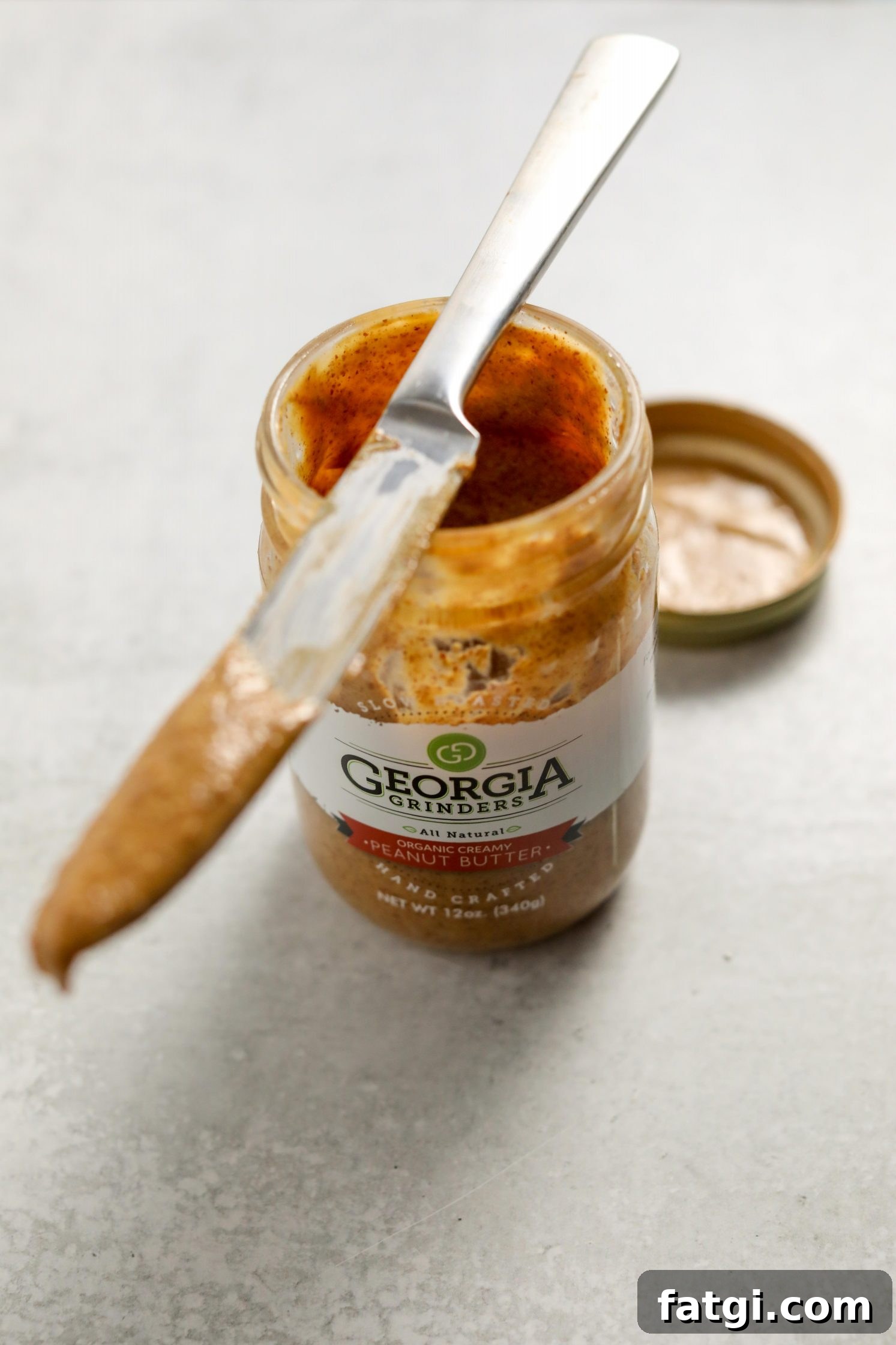 Authentic West African Peanut Stew Recipe 3 Georgia Grinders Organic Peanut Butter opened with a knife by Flora & Vino