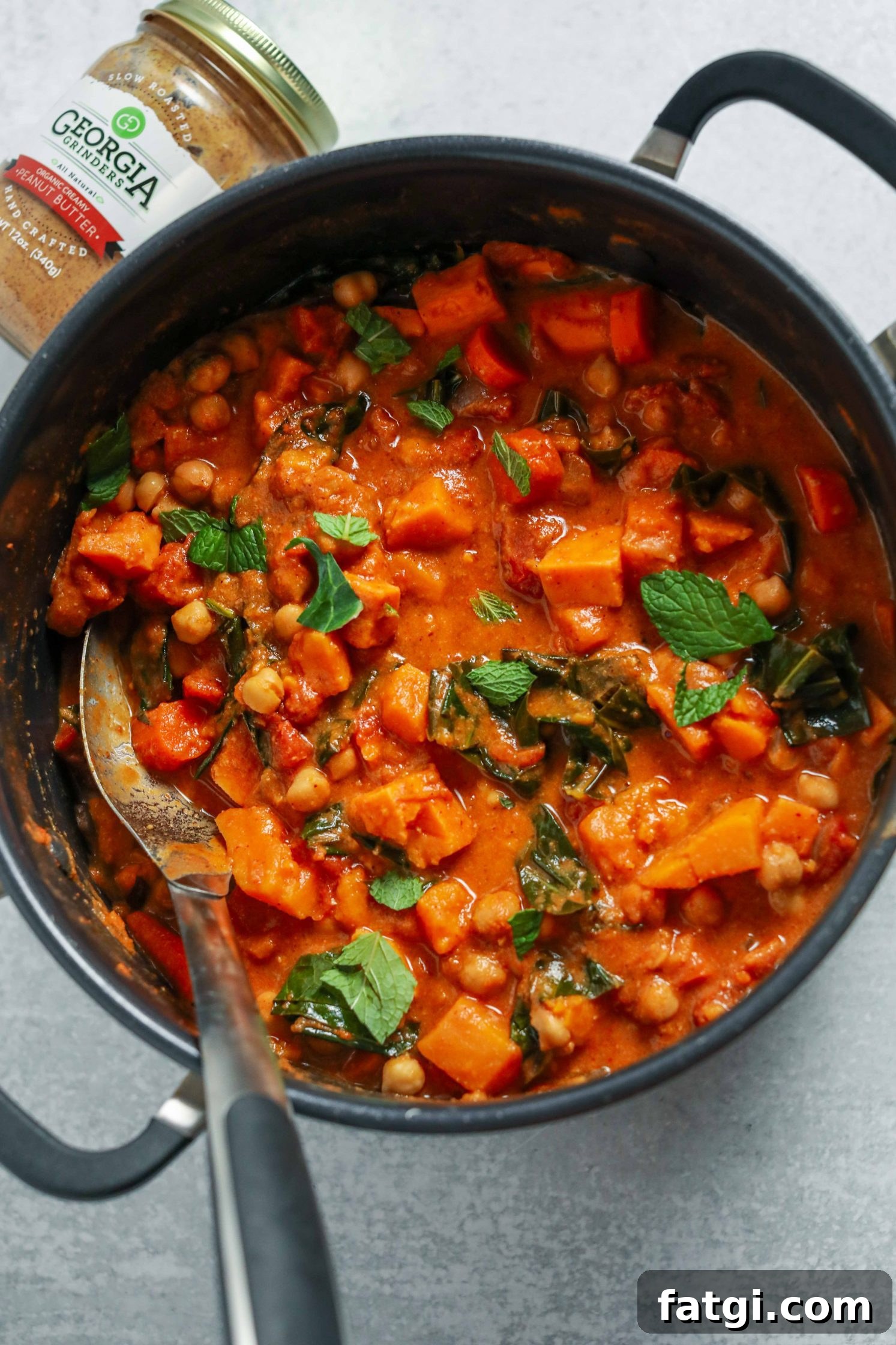 Authentic West African Peanut Stew Recipe 4 African Peanut Butter Stew cooked in pot with a big spoon by Flora & Vino