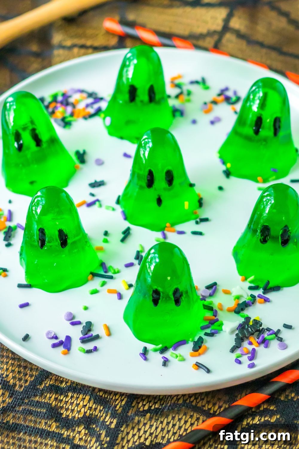 Ghost Jello Shots for Halloween Parties 7 ghost shaped jello shots sitting on table on a plate with sprinkles