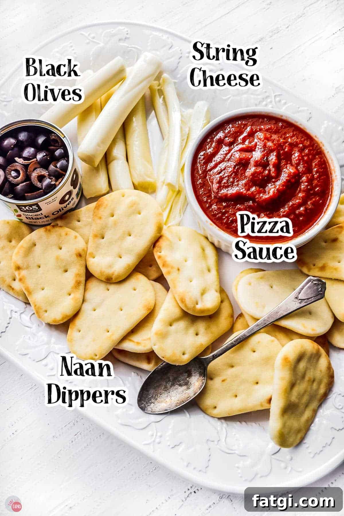 Mini Mummy Pizza Dippers for Halloween 3 mini naan bread on a white plate with tomato sauce, olives, and cheese