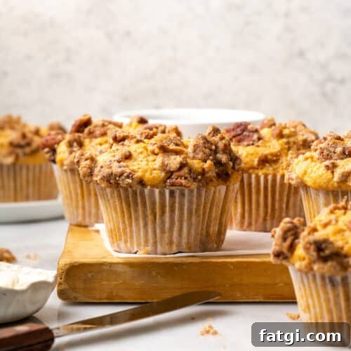 Sweet potato muffins cooling on a wooden cutting board.