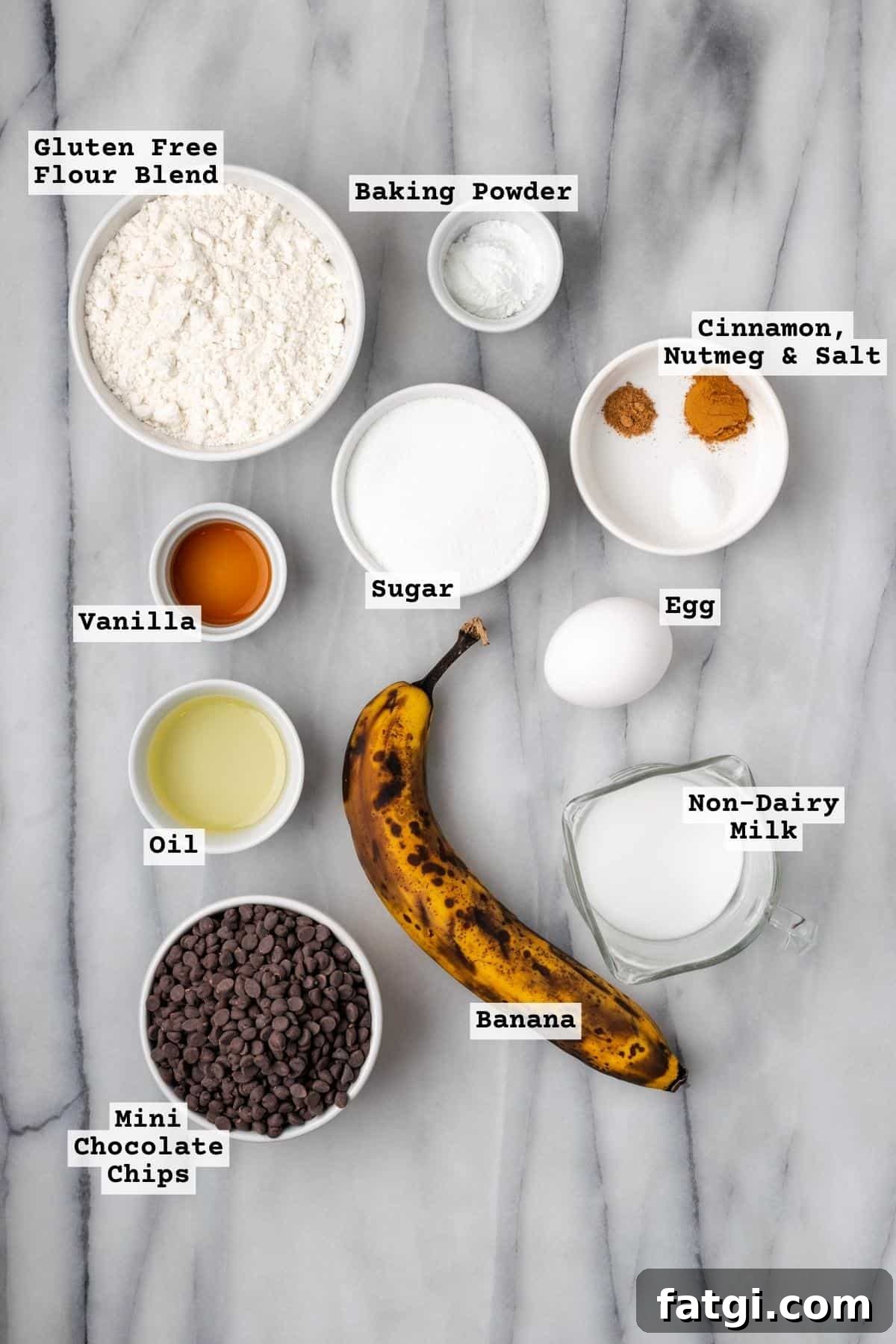 Ingredients for chocolate chip banana muffins on a marble countertop.
