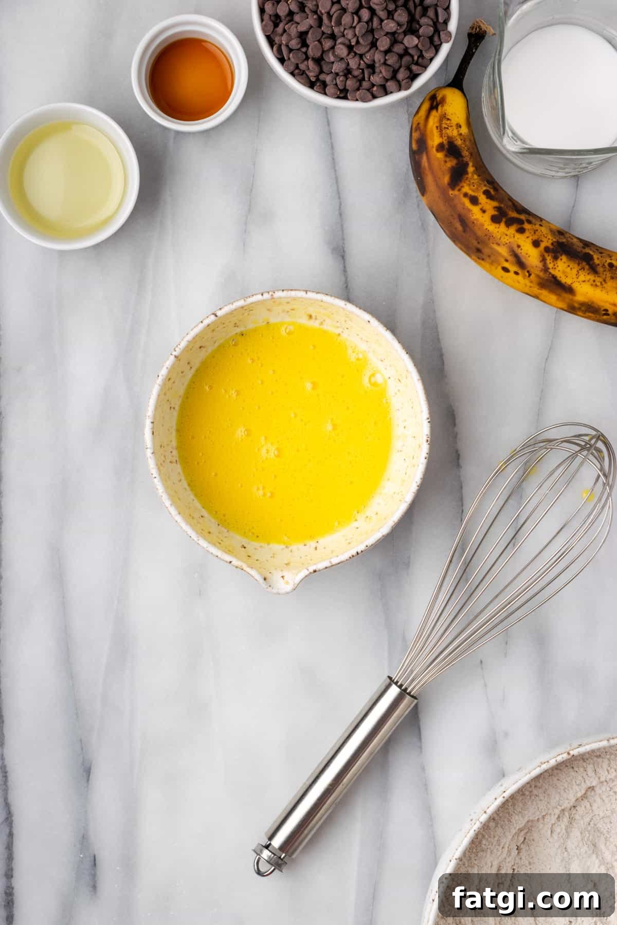 An egg that has been whisked until bubbly in a small white bowl.