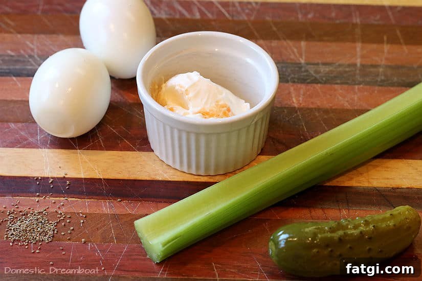 Ingredients for dill pickle egg salad on a wood cutting board.