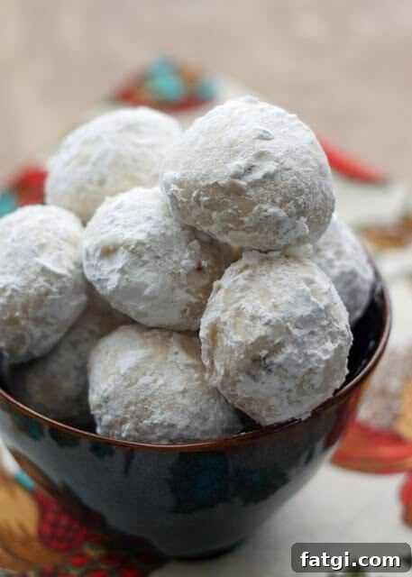 A pile of Mexican Wedding Cookies topped with powdered sugar in a bowl