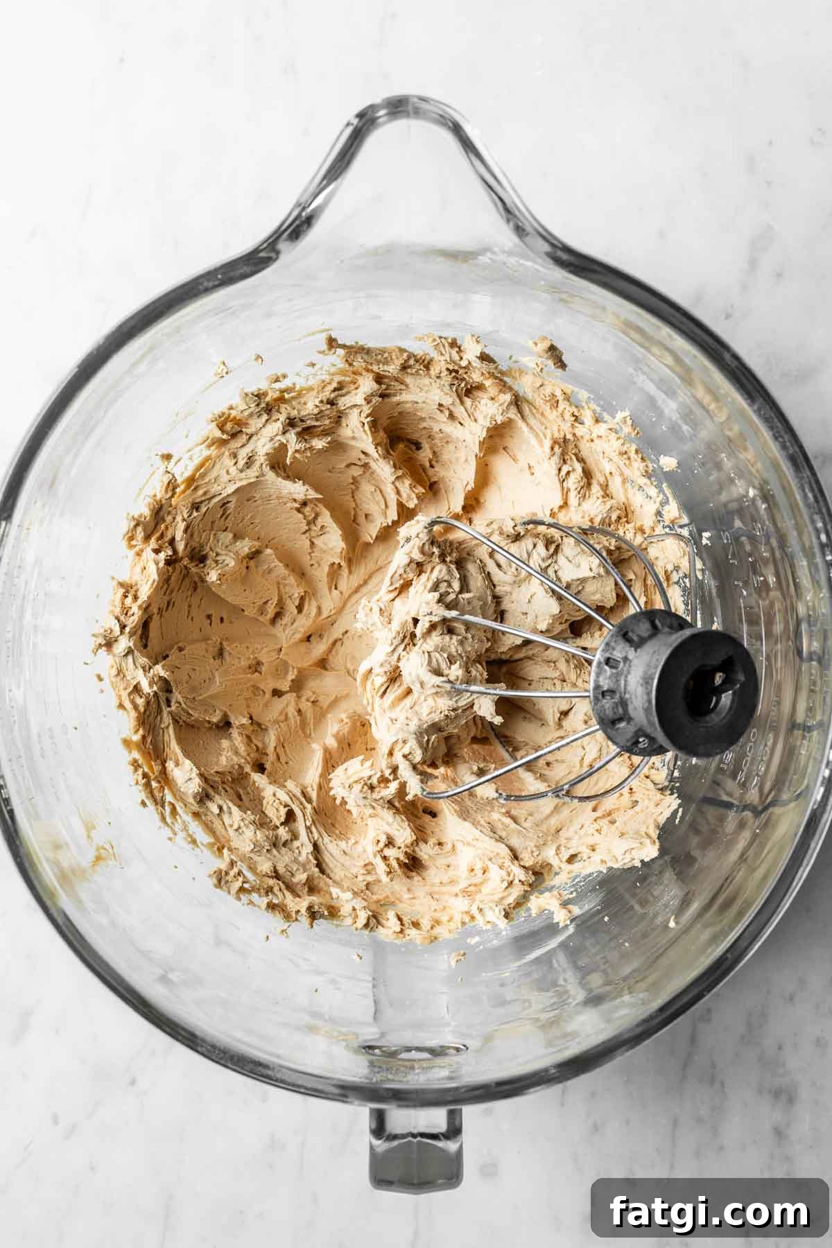 Whipped coffee buttercream frosting in a glass mixing bowl.