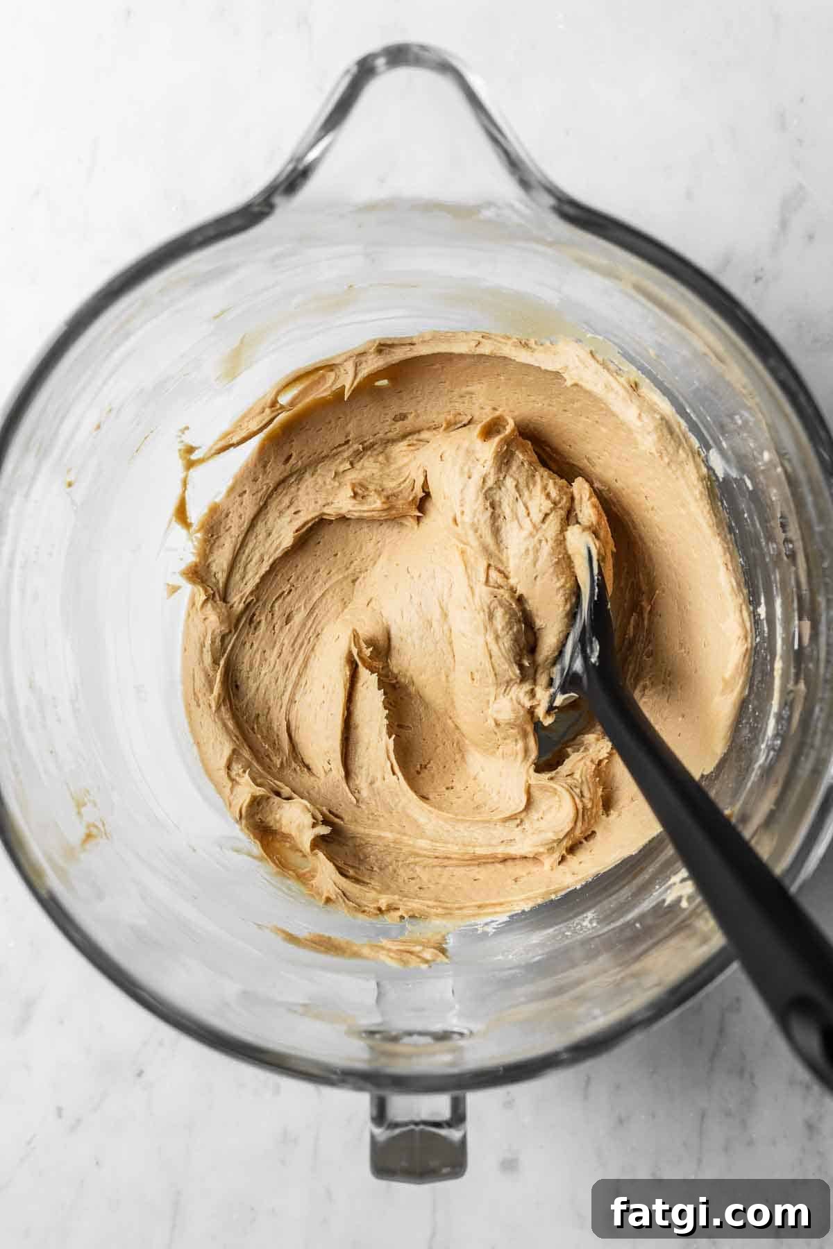 Espresso mascarpone frosting in a glass mixing bowl.