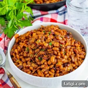 Homemade Baked Beans Recipe 2 A bowl of baked beans with bacon on top.