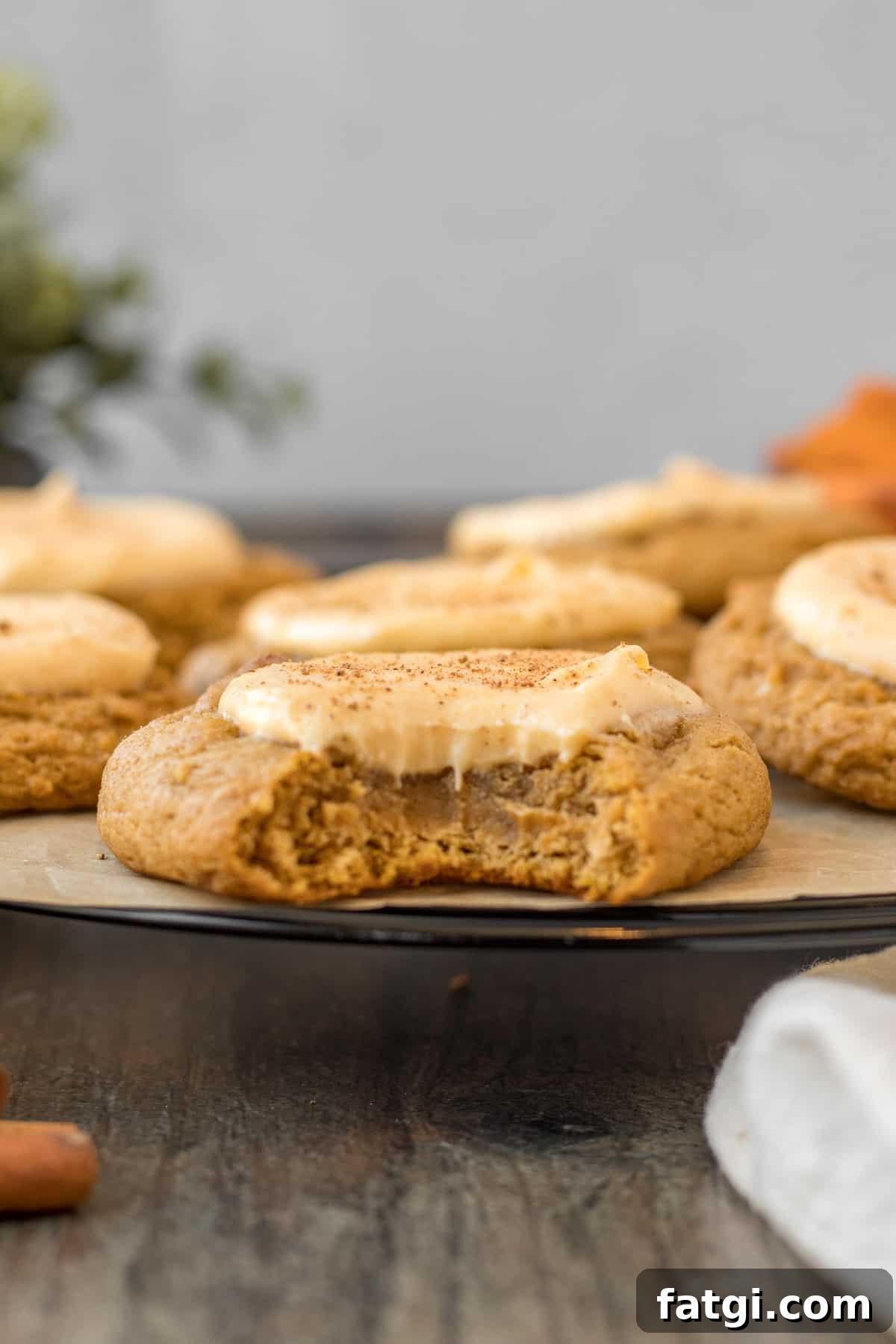 Creamy Pumpkin Cheesecake Cookies 4 close up view of a pumpkin cookie with cheesecake filling with a bite out of it