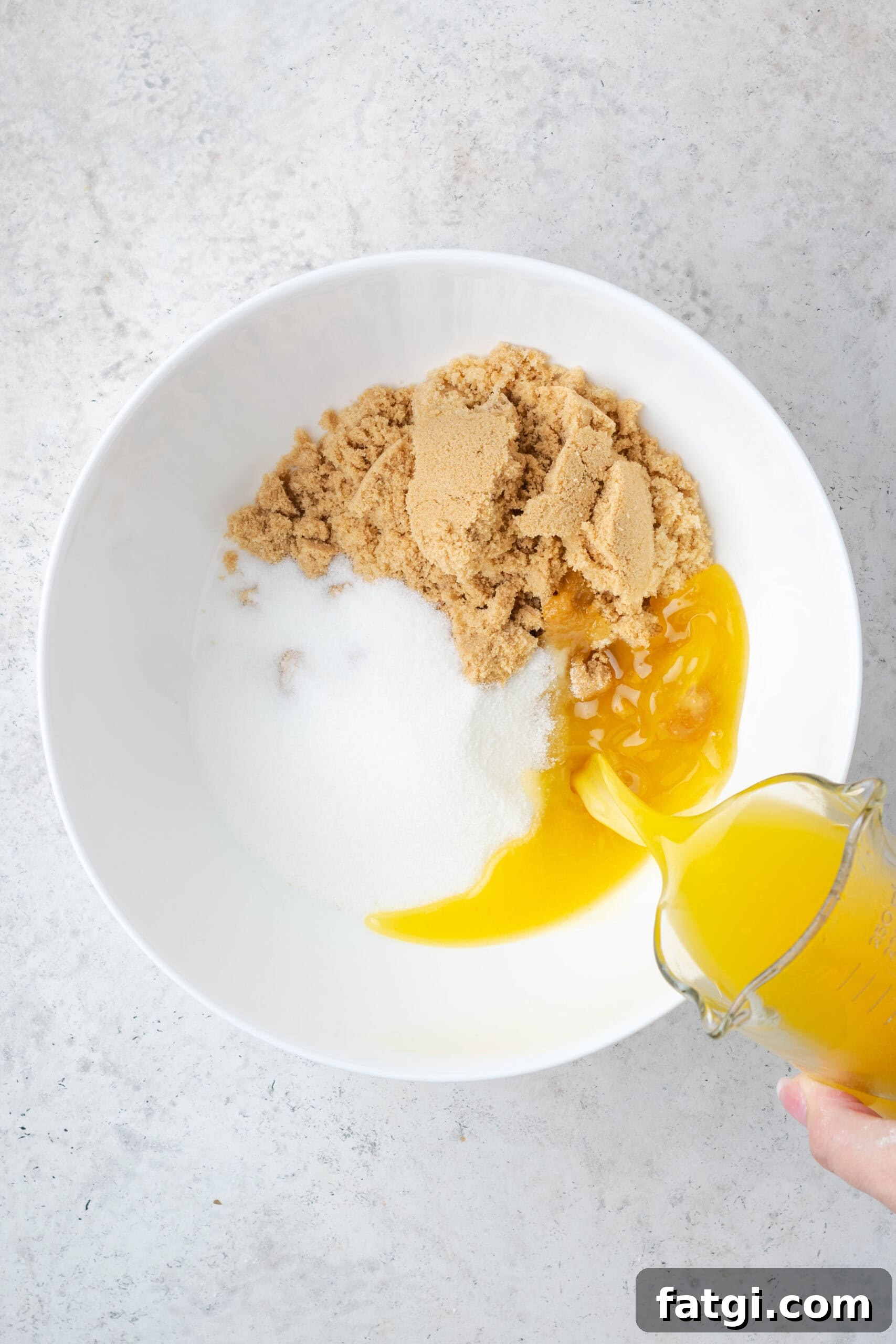 Brown sugar, white sugar and melted butter combined in a large mixing bowl. 