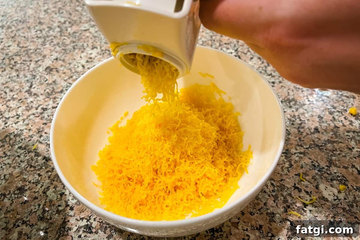 Shredding cheddar into a white bowl