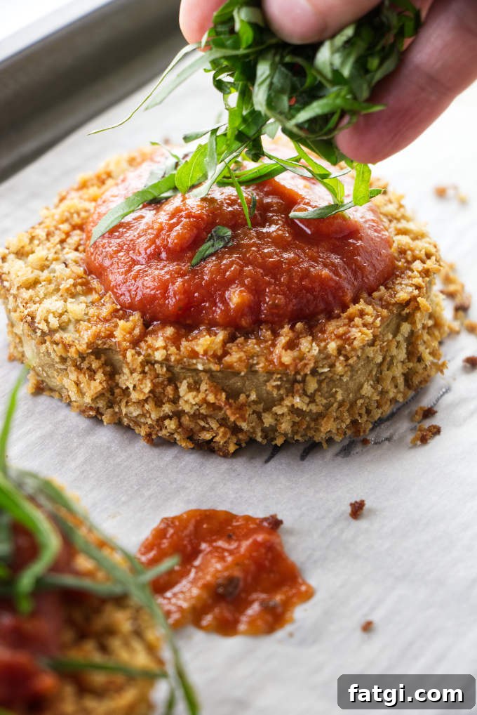 Topping eggplant slices with basil.