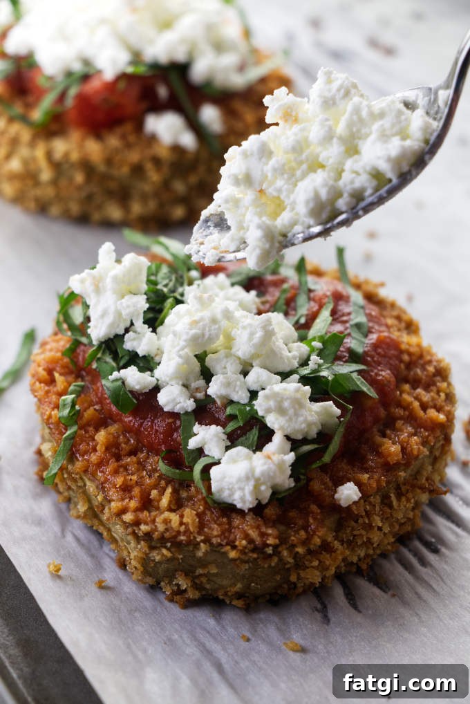 Topping eggplant steaks with goat cheese.