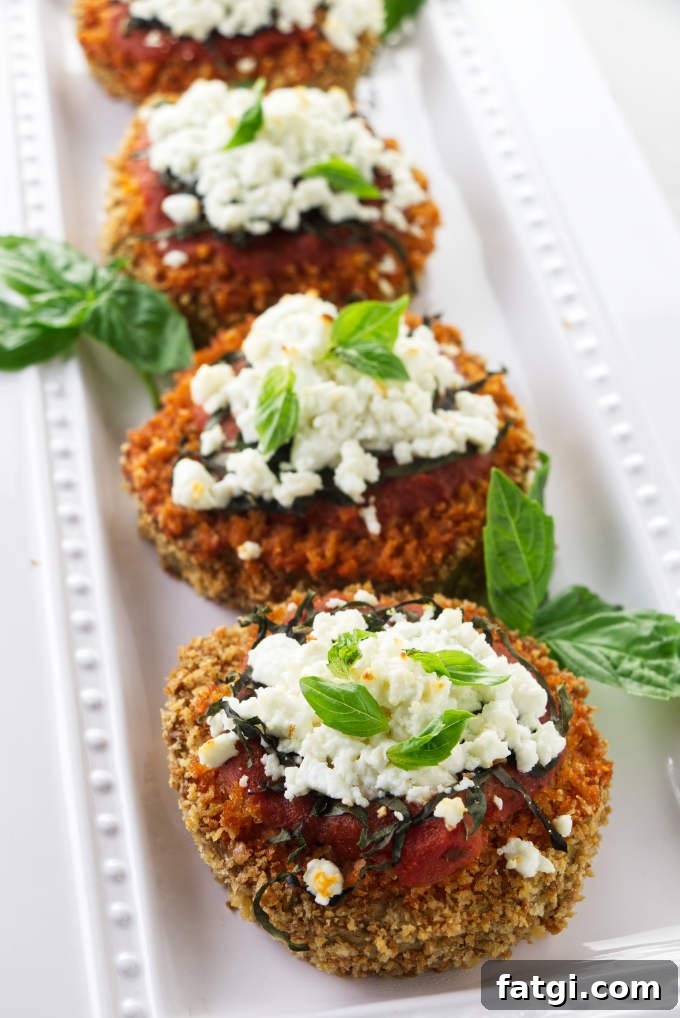 Slices of baked eggplant rounds with goat cheese and marinara sauce.